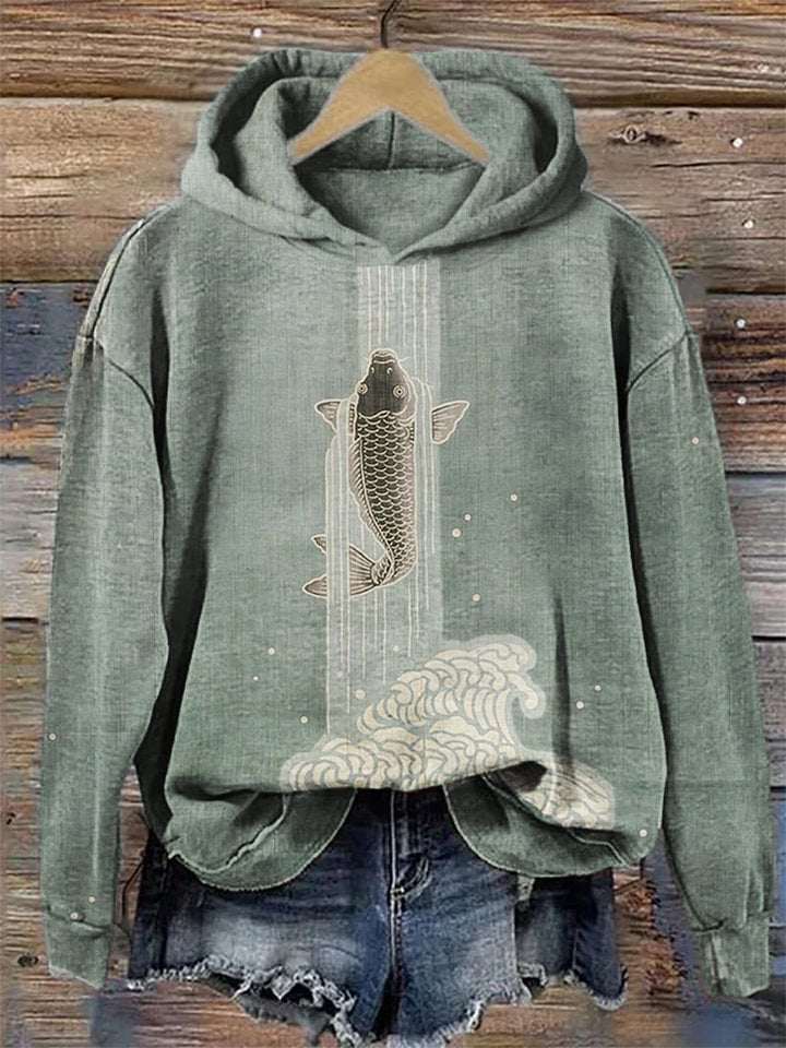 Green hoodie with fish design on a wooden background