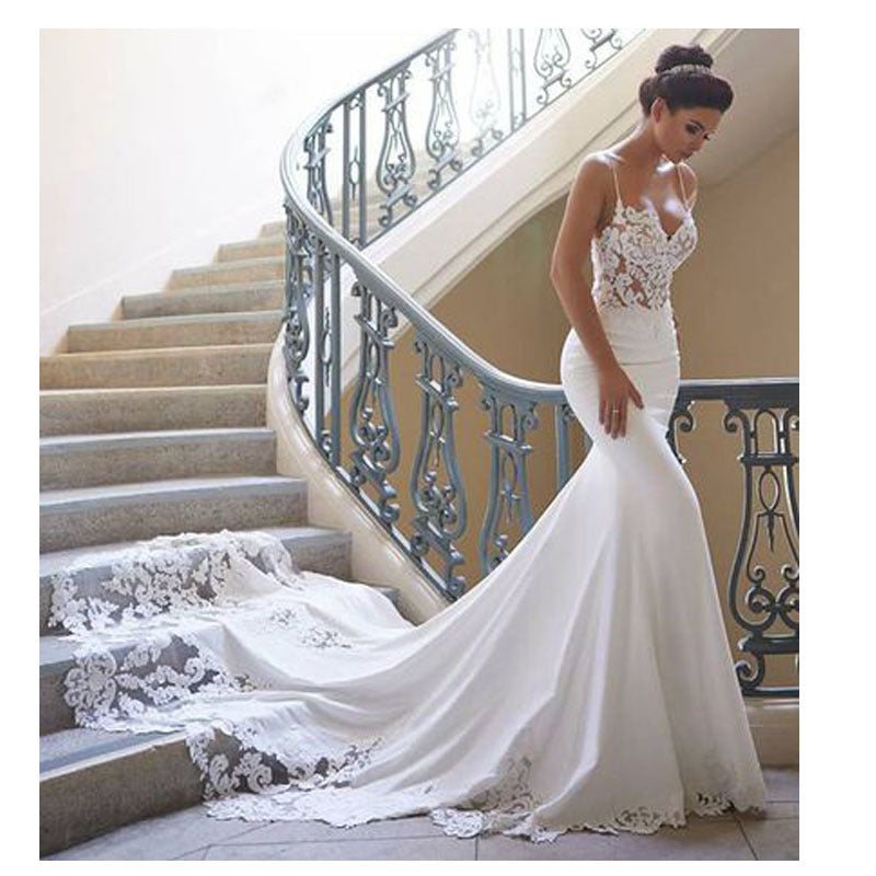 Woman in a white wedding dress standing on a staircase with decorative railings.