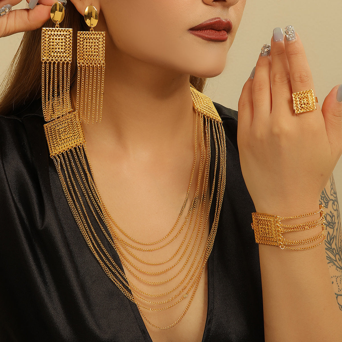 Woman wearing gold jewelry including earrings, necklace, bracelet, and ring.