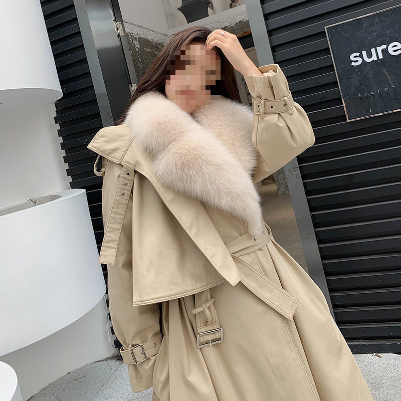 Person wearing a beige trench coat with fur collar in an urban setting by millivan