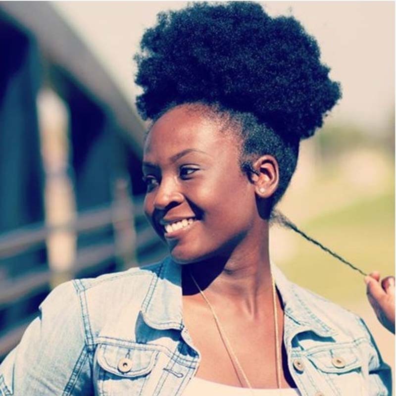 Woman with an afro hairstyle wearing a denim jacket outdoors
