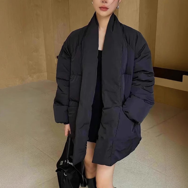 Person wearing a long black puffer coat in an indoor setting