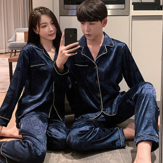 Two people wearing matching blue pajama sets sitting on the floor in a kitchen.
