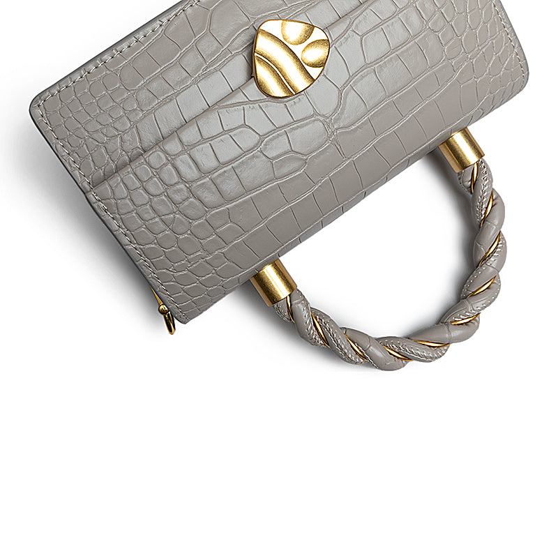Gray textured handbag with gold accents on a white background