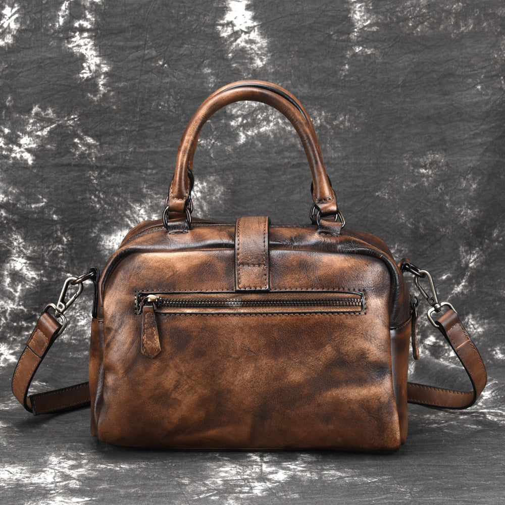 Brown leather handbag on a textured gray background