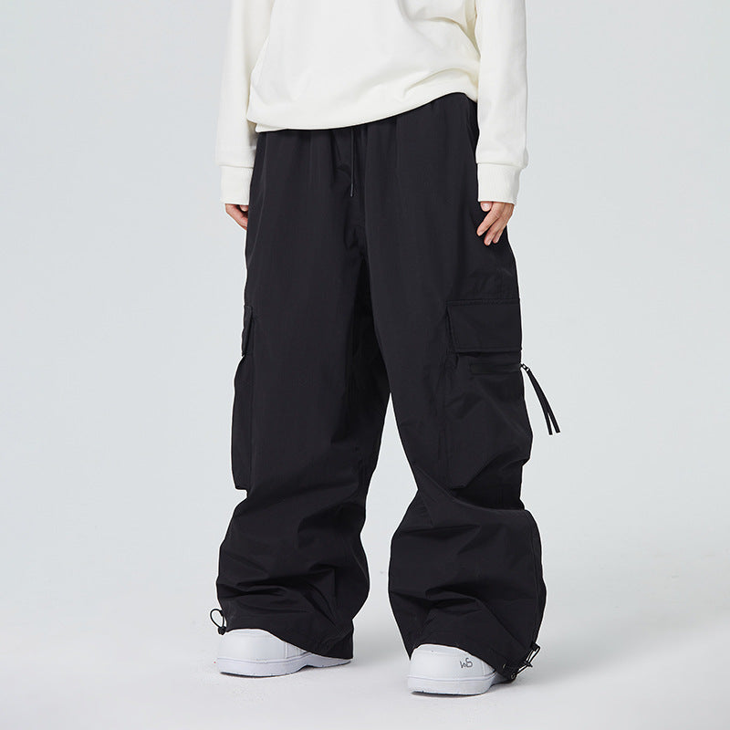 Person wearing black cargo pants and white sneakers on a plain background