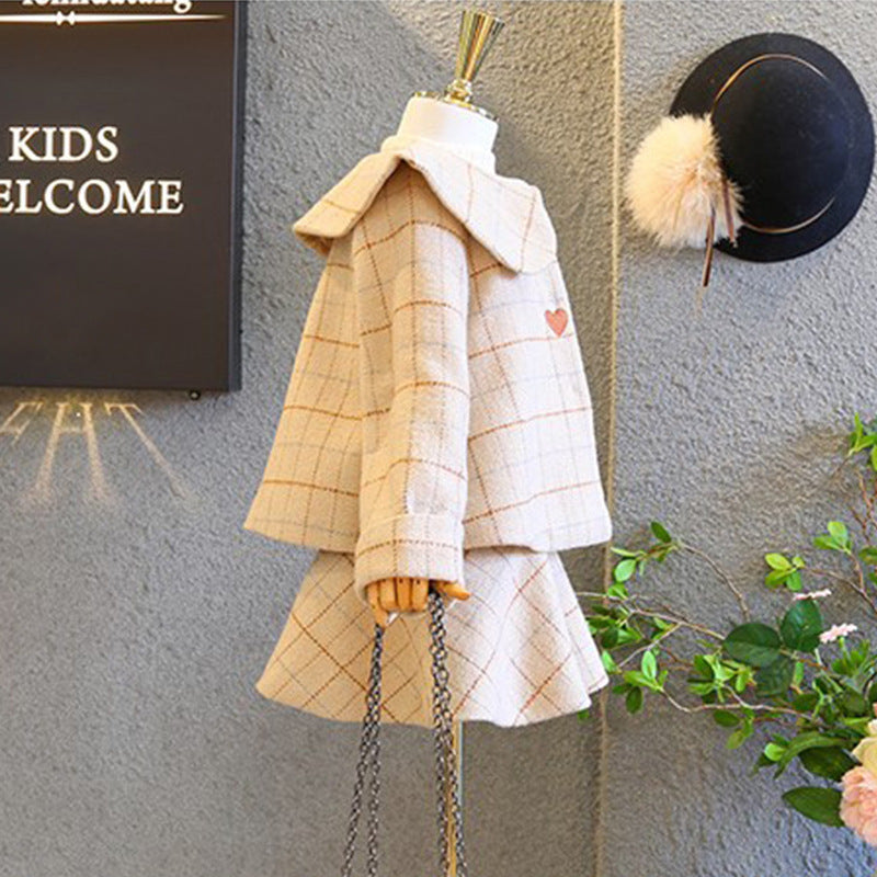 Children's clothing set on a mannequin with a 'Welcome' sign in the background