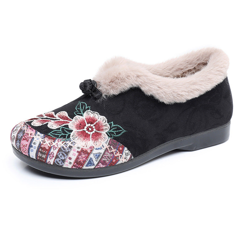 Black slipper with floral design and fluffy lining on a white background