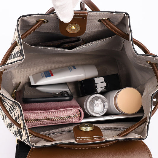 Open handbag with various items including a phone, bottle, and wallet.