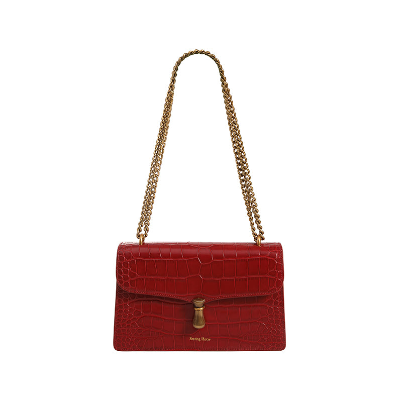 Red handbag with gold chain strap on a white background