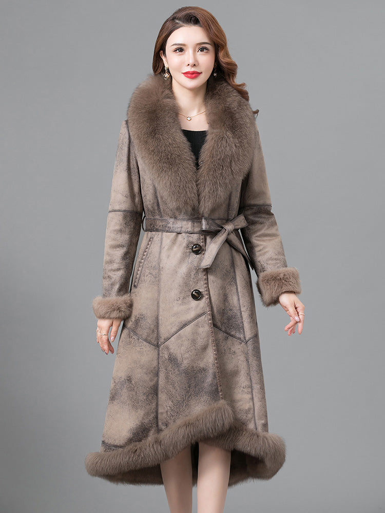 Woman wearing a long brown coat with fur trim on a gray background
