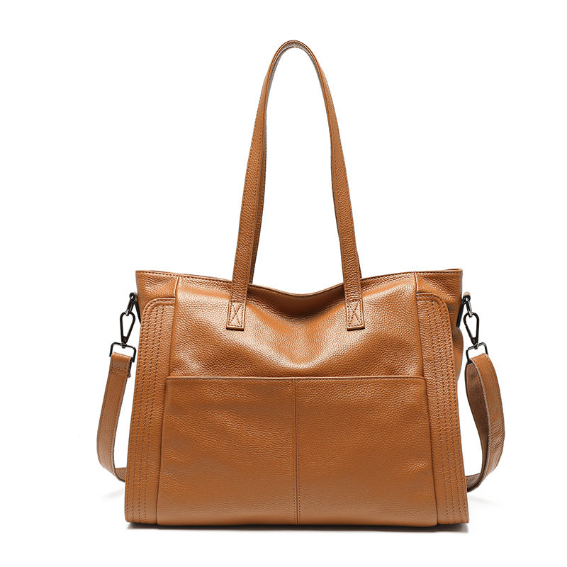 Brown leather tote bag with shoulder strap on a white background