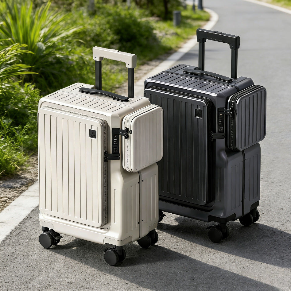 Two suitcases, one white and one black, on a paved path with greenery in the background.