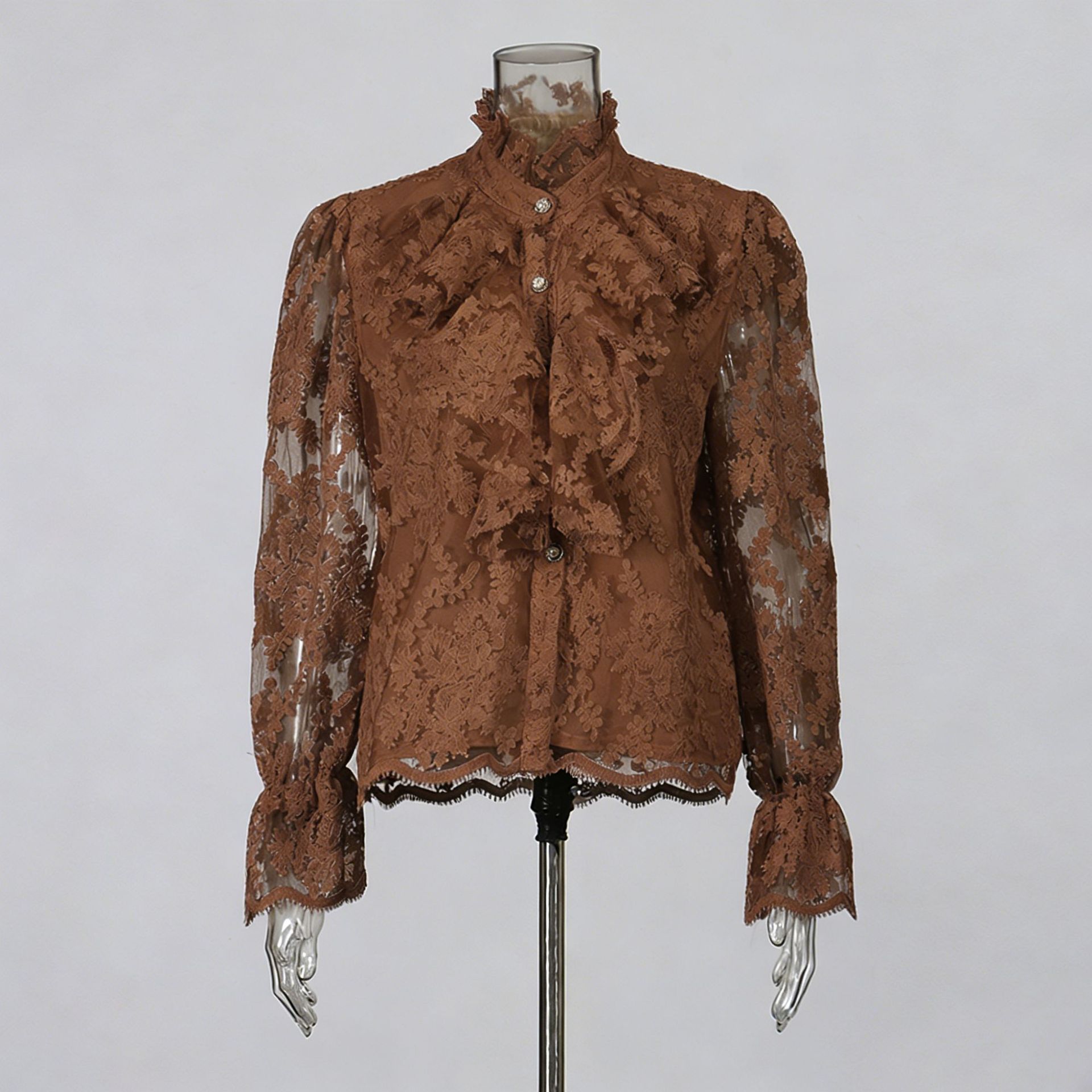 Brown lace blouse on a mannequin against a gray background