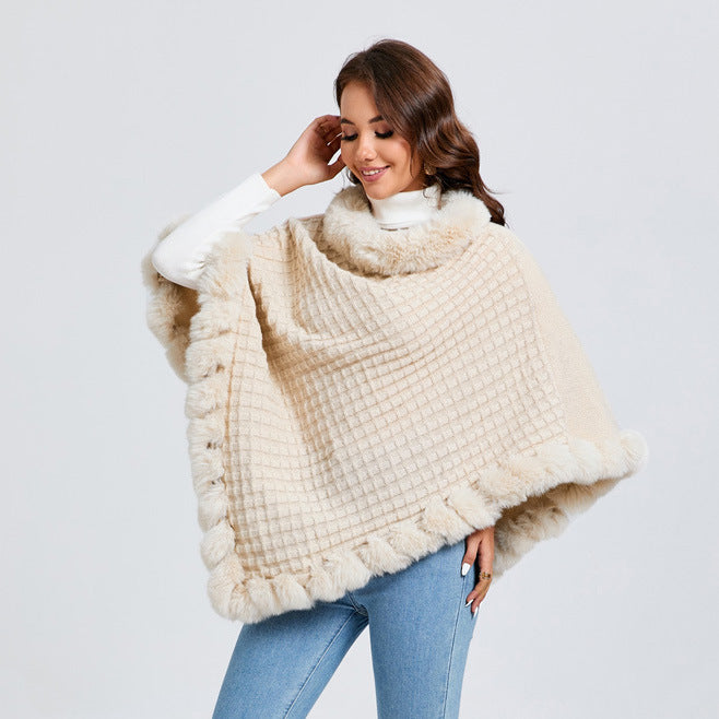 Woman wearing a cream-colored poncho with fur trim on a light gray background