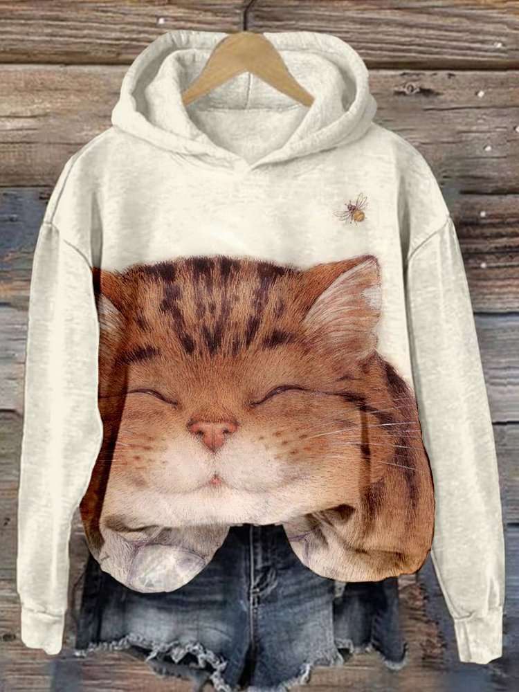 Gray hoodie with a cat face design on a wooden background