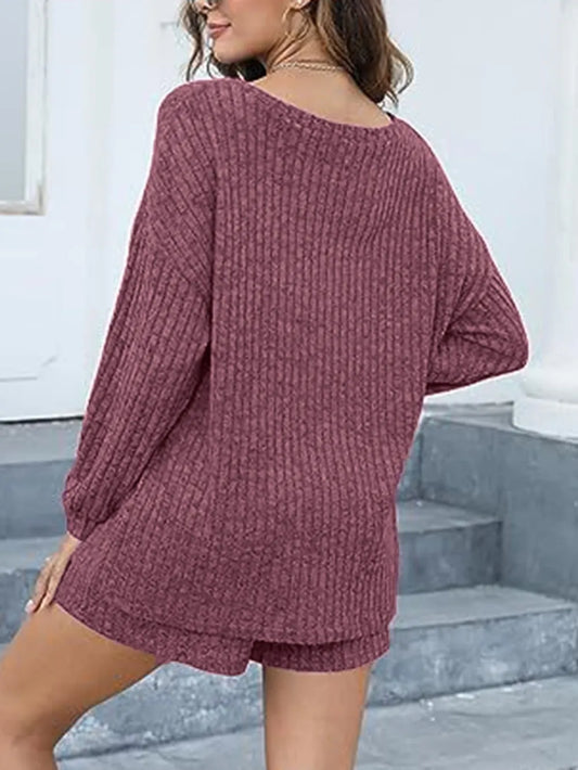 Person wearing a maroon knitted outfit on a neutral background