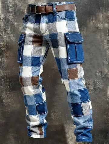 A pair of patchwork cargo pants featuring a blue, white, and brown plaid pattern with contrasting blue suede-like flap pockets, styled with a brown belt against a dark textured background.