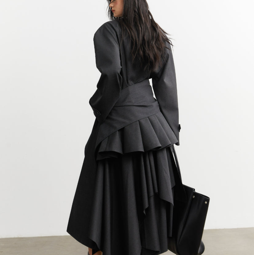 Woman wearing a black layered dress with a plain background