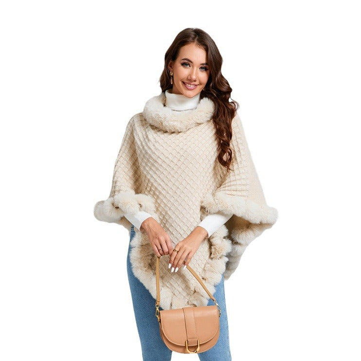 Woman wearing a beige knitted poncho with fur trim on a white background