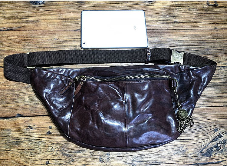 Brown leather fanny pack on a wooden surface