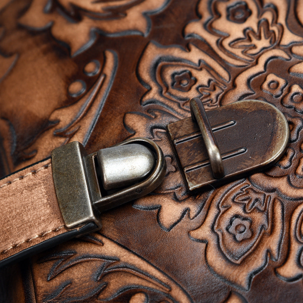 Close-up of a brown leather strap with metal buckle on a similarly patterned background