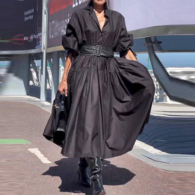 Person wearing a black dress with a belt in an urban setting