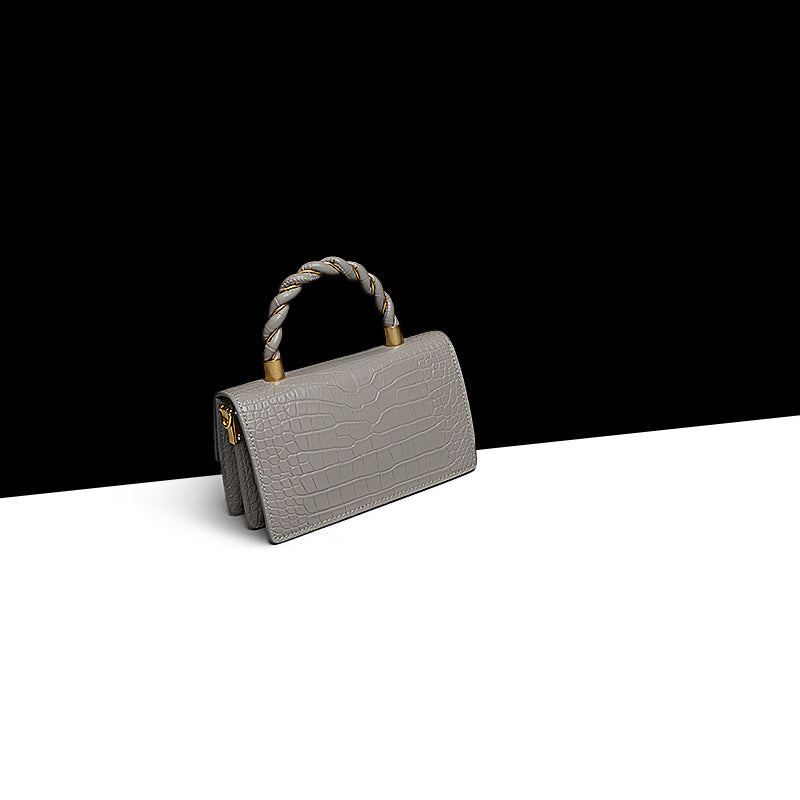 Gray handbag with a rope handle on a black and white background