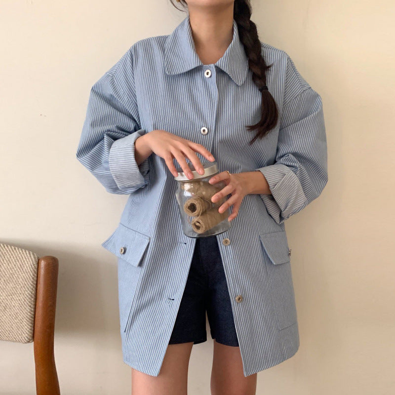 Person wearing a blue checkered shirt holding a glass jar with a wooden lid.
