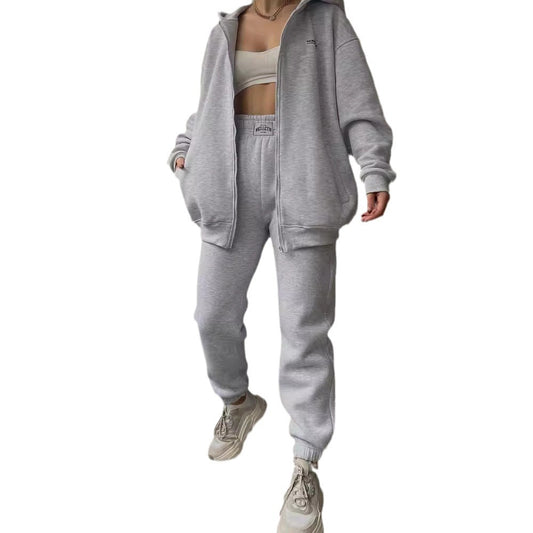 Person wearing a gray tracksuit on a white background