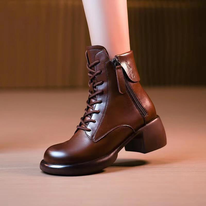 Brown leather ankle boots with a zipper on a neutral background