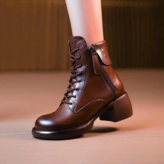 Brown leather ankle boots with a zipper on a neutral background