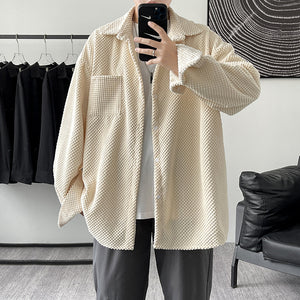 Person wearing a beige textured jacket in a clothing store.