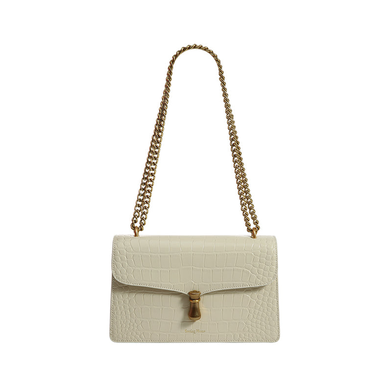 Cream-colored handbag with gold chain strap on a white background