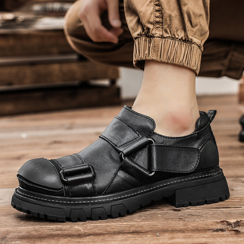Black leather shoe with buckle detail on a wooden floor
