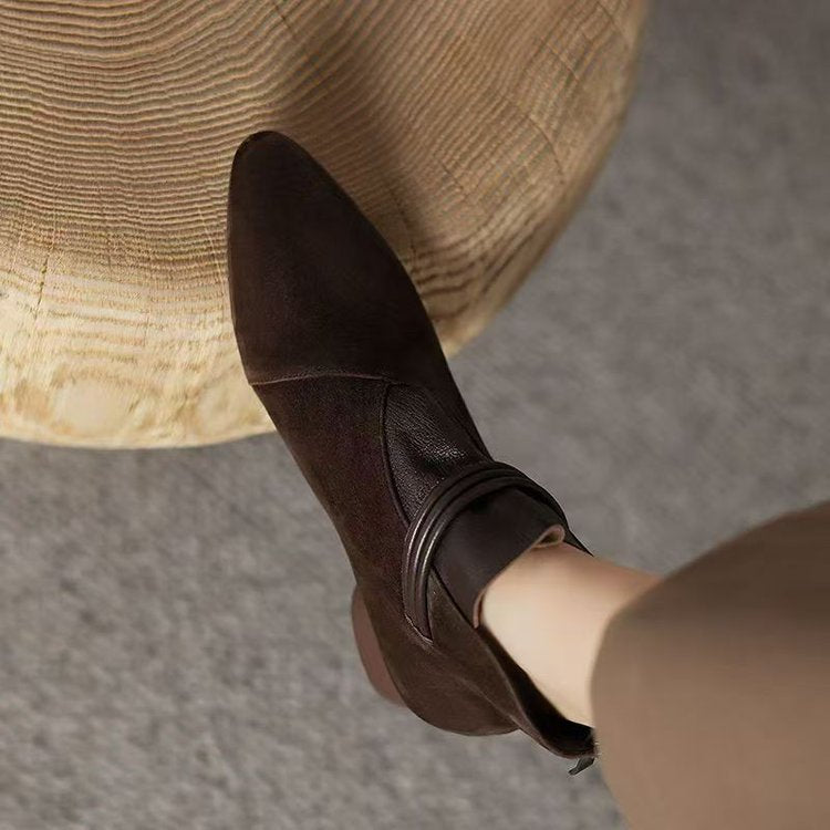 Brown leather shoe with a strap on a neutral background