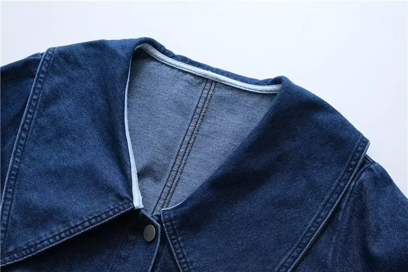 Close-up of a blue denim jacket on a light gray background