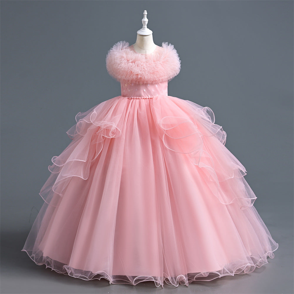 A pink ballgown dress displayed on a white mannequin against a solid gray studio background. The dress features a strapless bodice with fluffy feather trim around the neckline, a beaded waistband, and a voluminous layered tulle skirt with ruffled edges.