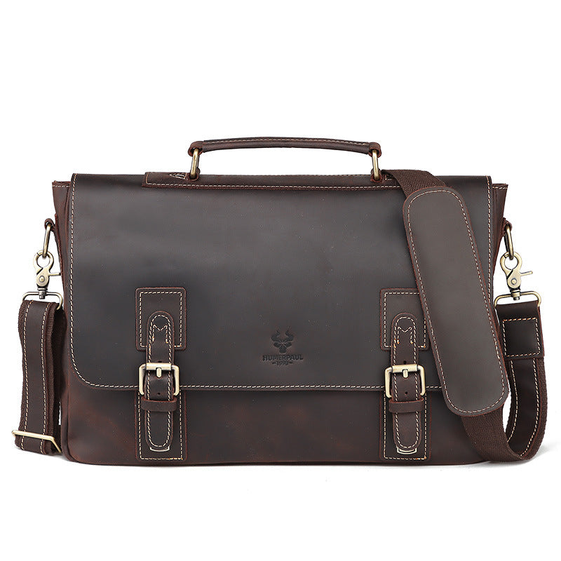 Brown leather briefcase with shoulder strap on a white background