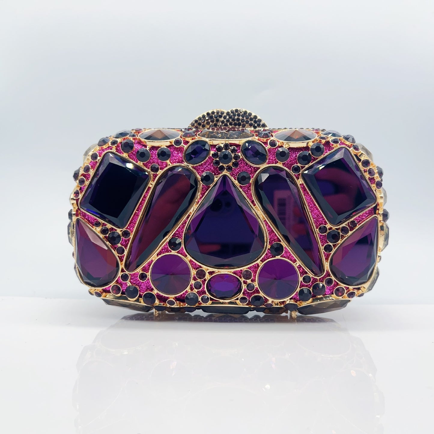Elegant clutch with purple gemstones on a light gray background