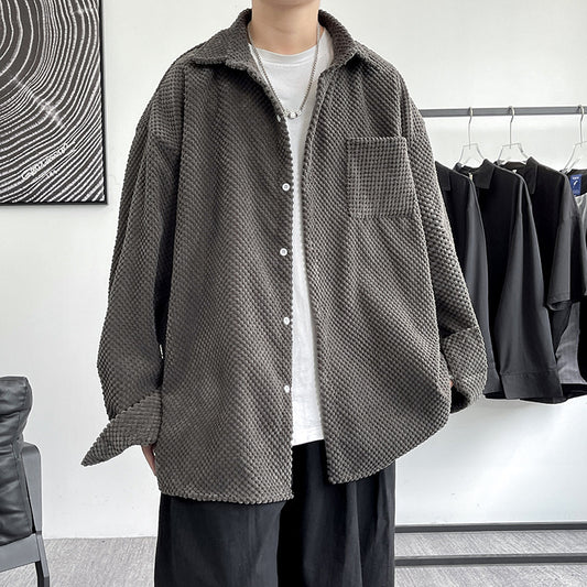 Person wearing a textured gray shirt over a white t-shirt in a clothing store.
