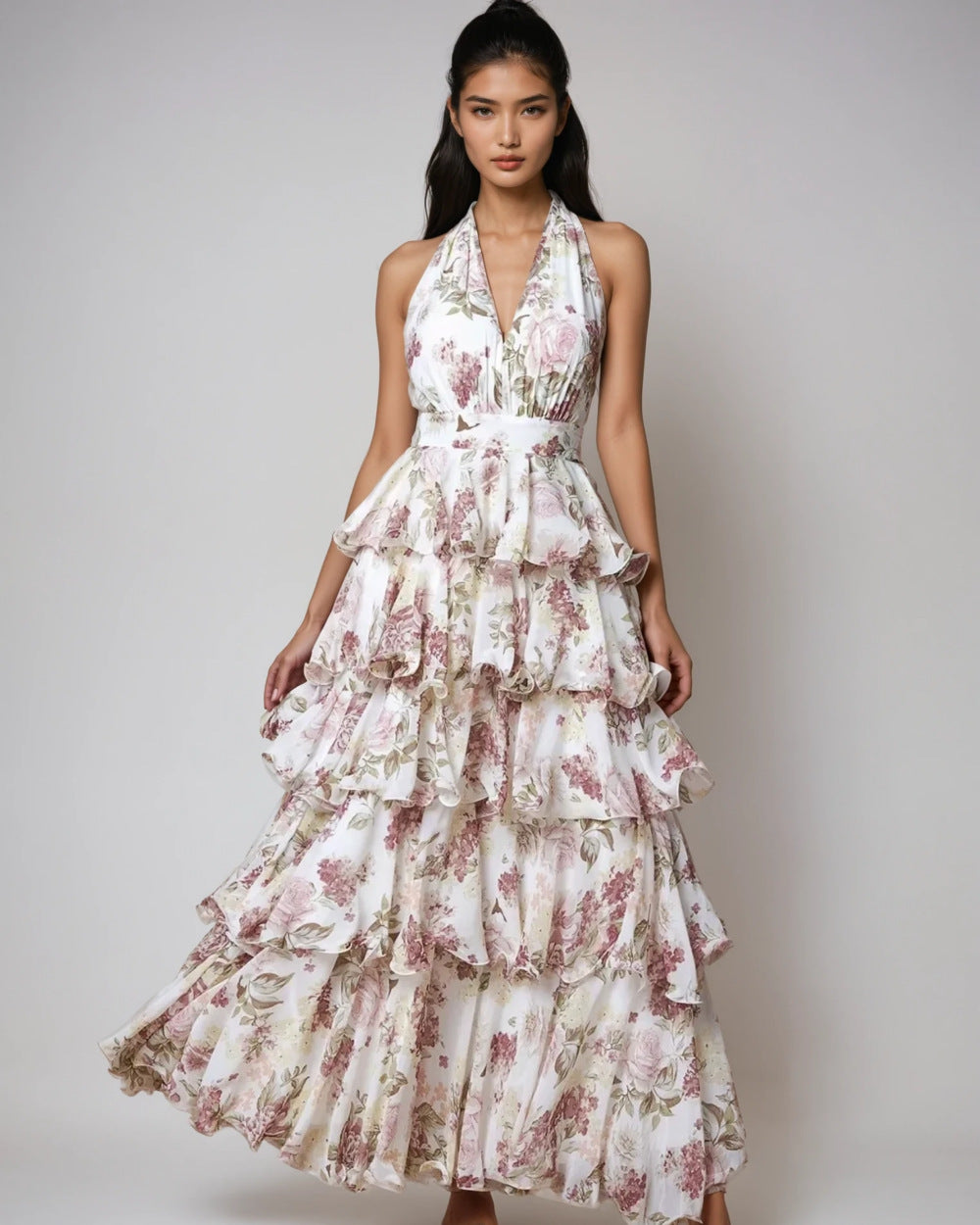 Woman wearing a floral tiered dress on a plain background