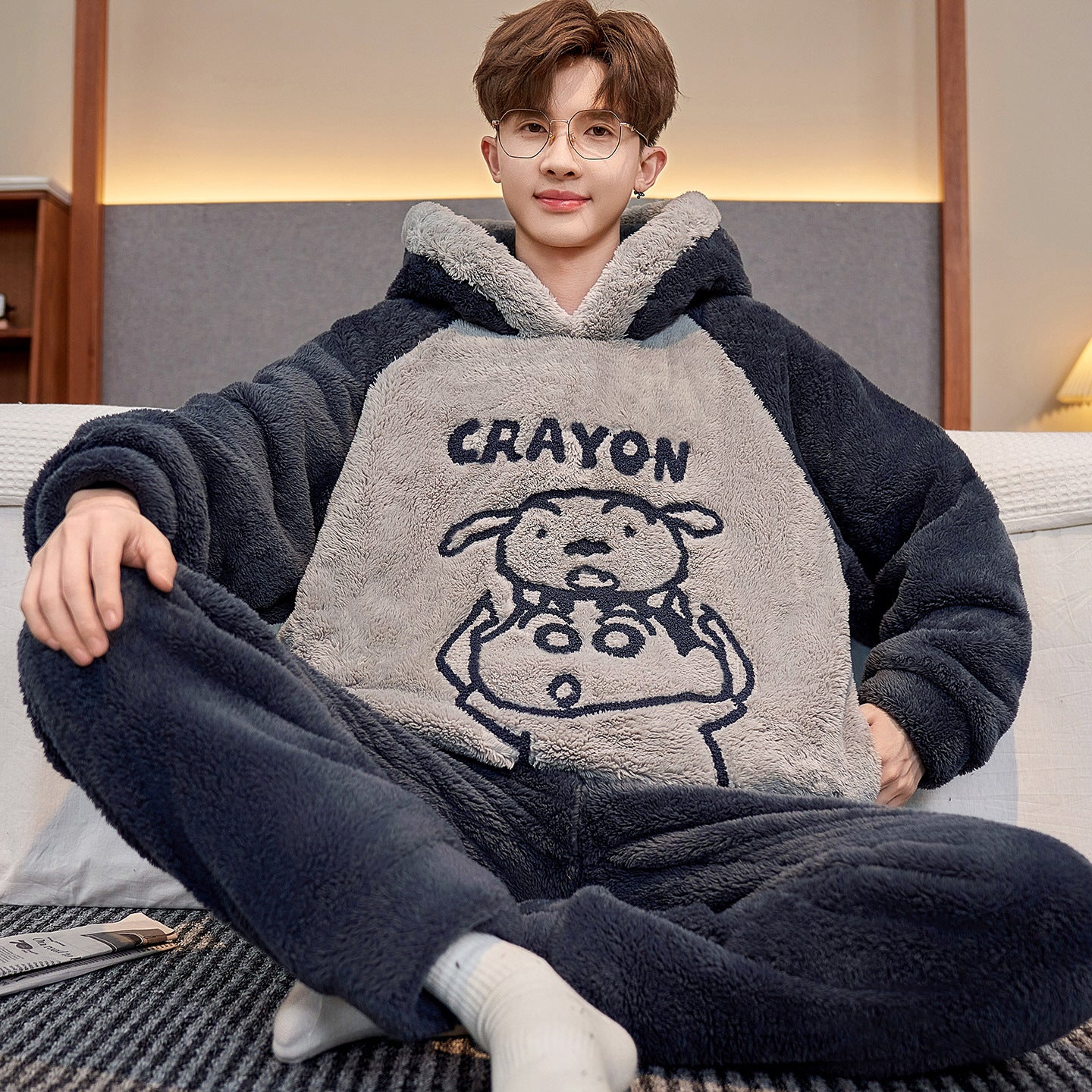 Person wearing a cozy fleece onesie with cartoon design on a couch.