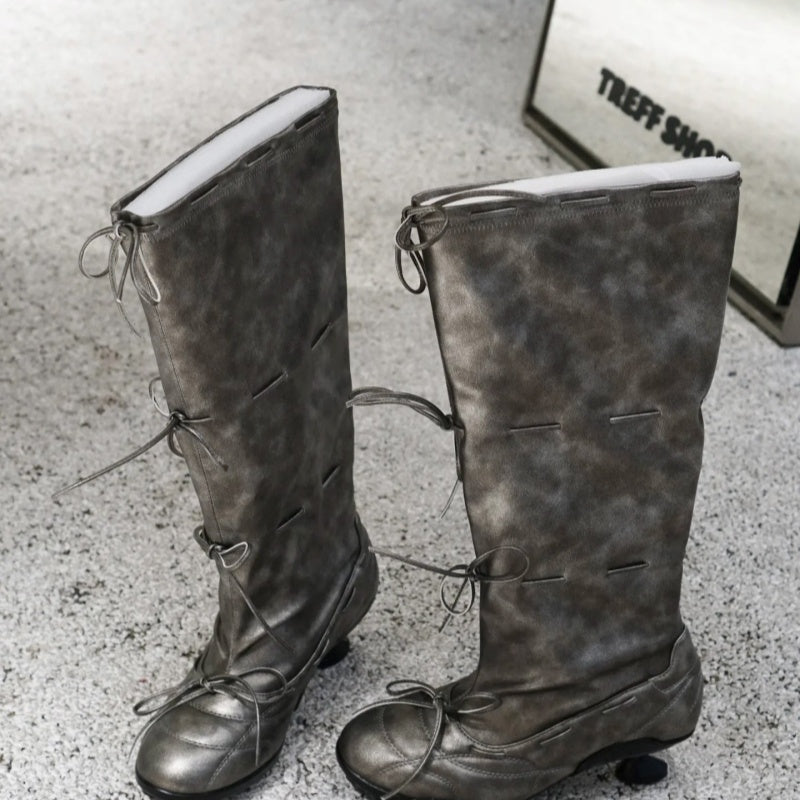 Pair of gray knee-high boots on a textured surface with 'Treff Shoes' branding.