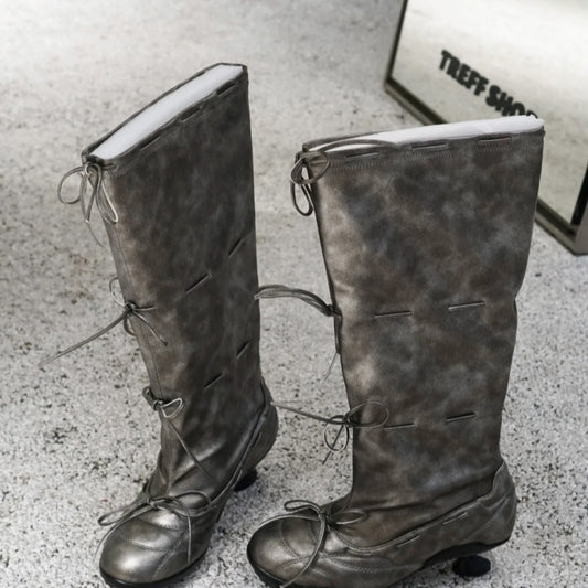 Pair of gray knee-high boots on a textured surface with 'Treff Shoes' branding.