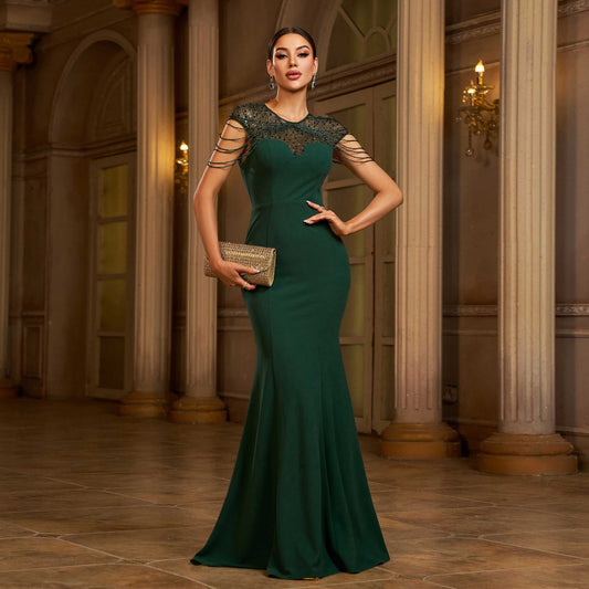 Woman in a green evening gown standing in an elegant interior setting by millivan
