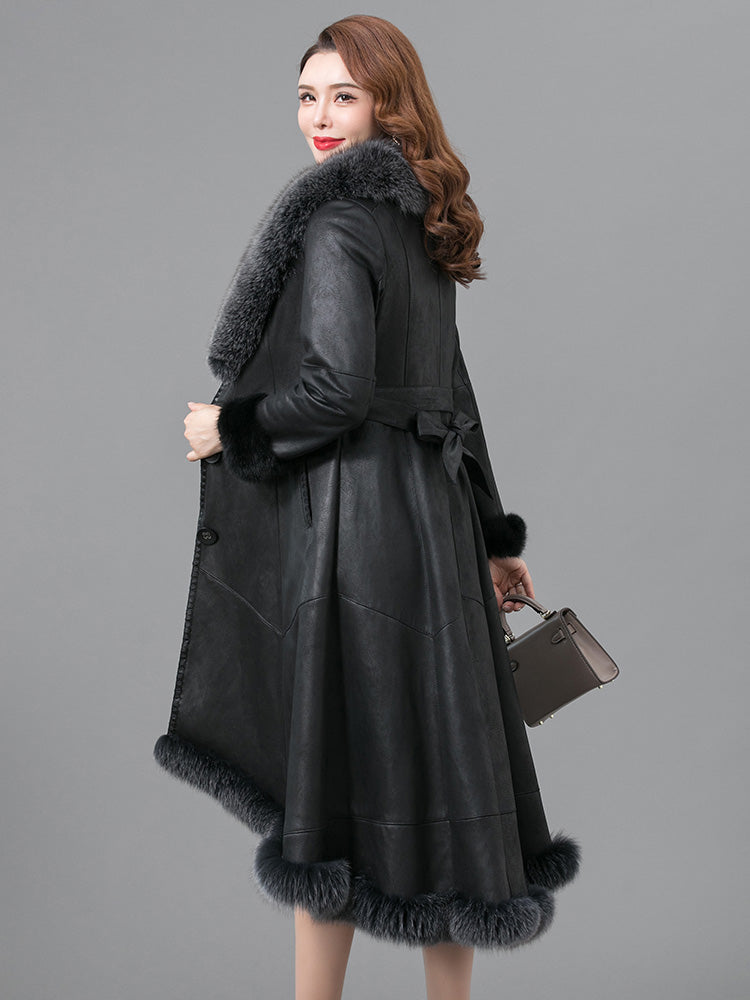 Woman wearing a black leather coat with fur trim on a gray background