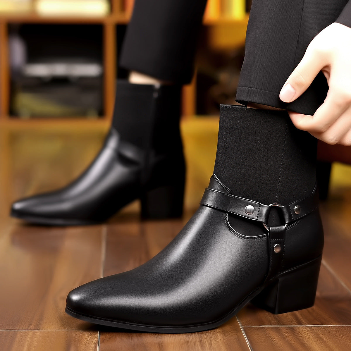 Person adjusting a black leather boot with a strap on a wooden floor.