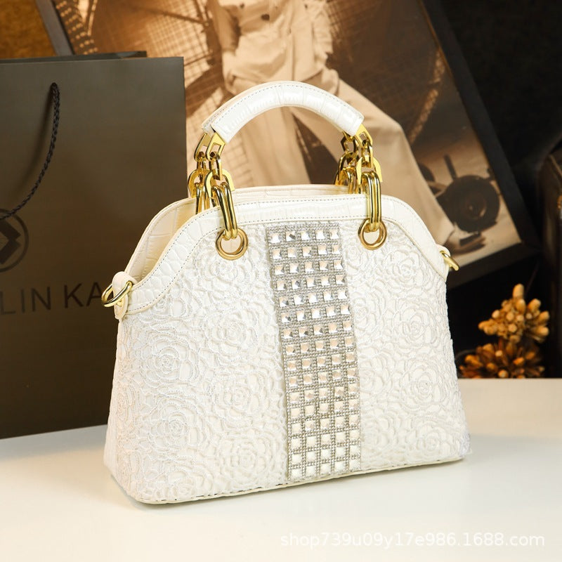 White handbag with gold accents on a blurred background