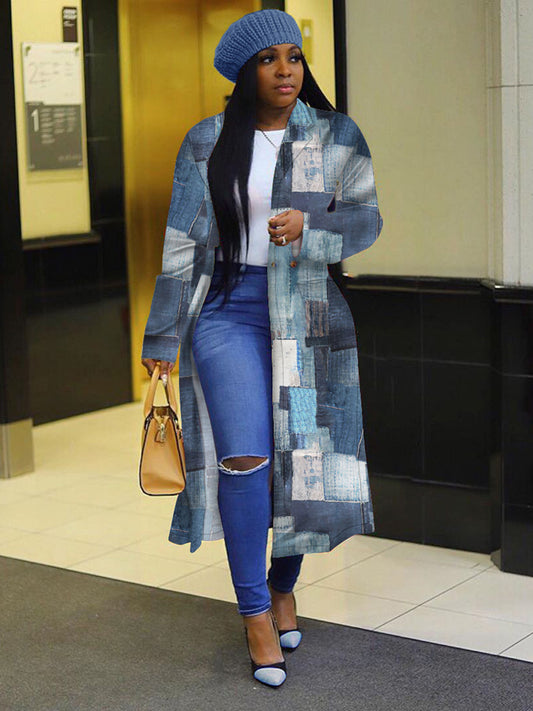 Woman wearing a long blue patchwork coat, blue jeans, and a matching blue beanie inside a building.